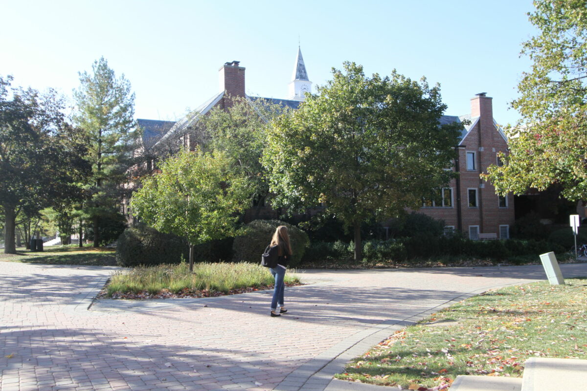 A photo of a woman walking outside Wheaton Buswell Library