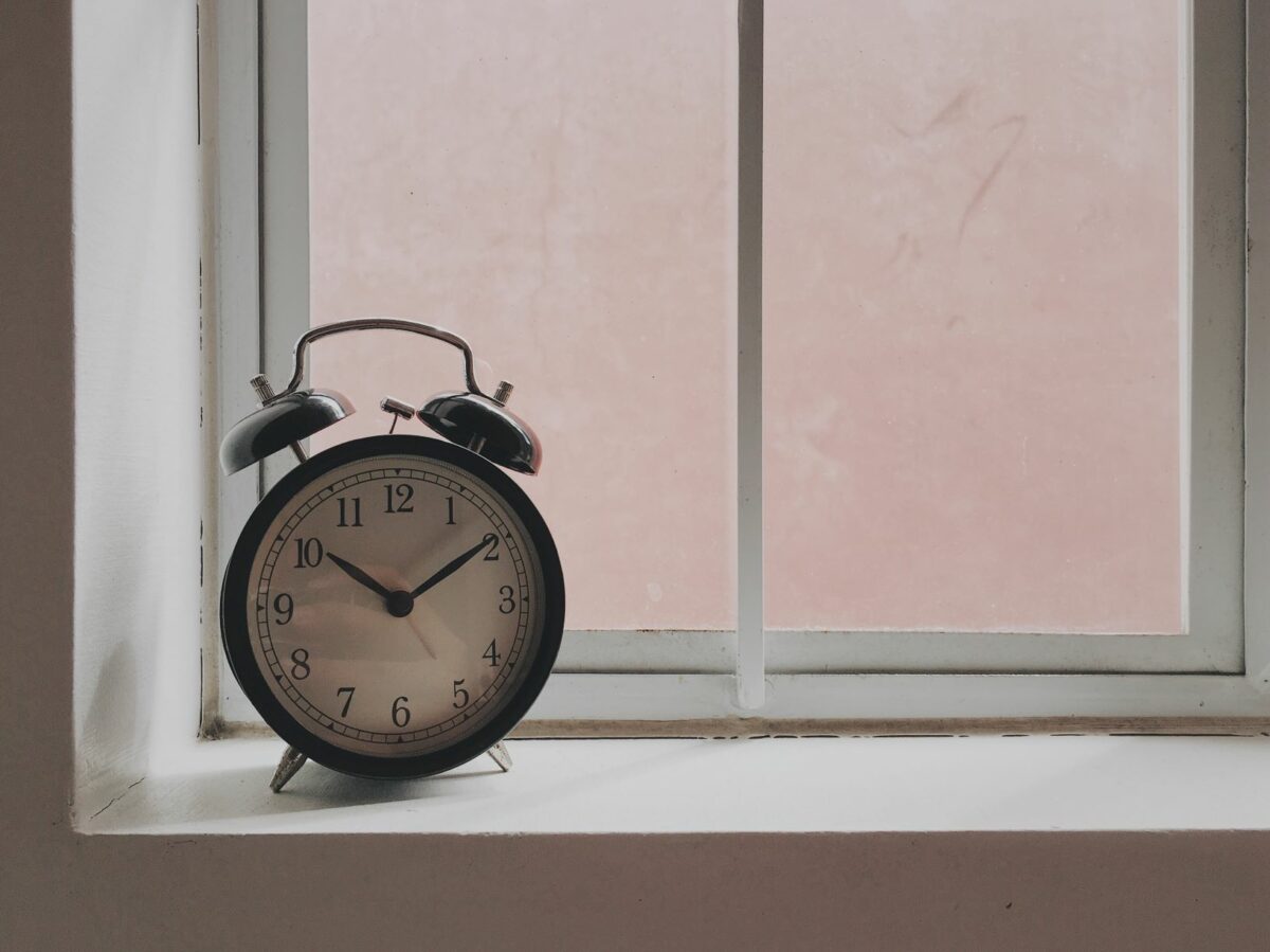 A photo of an alarm clock on a windowsill