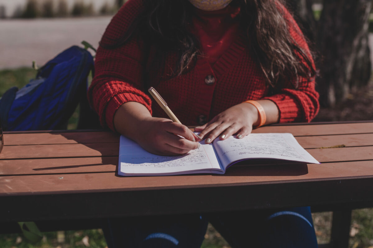 A photo of a woman's hands writing in a journal